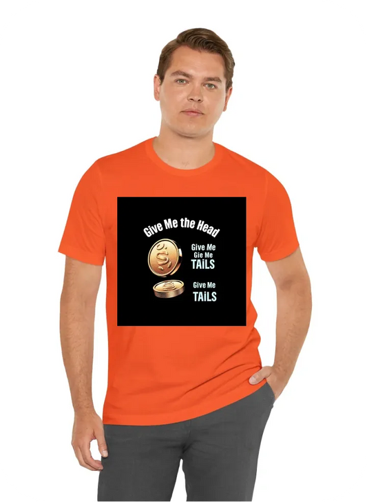 A visually striking t-shirt design featuring a large graphic of a flipping coin with a shiny metallic 'Heads' side prominently displayed. The phrase "Give Me the Head" arches above the coin, rendered in a bold, modern font that contrasts sharply with the